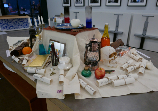 table with Nethack themed decorations such as a skull, paper scrolls, and glass bottles