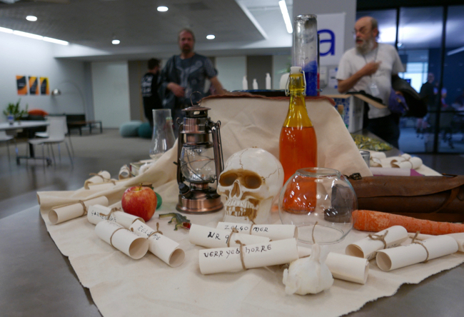 table with Nethack themed decorations such as a skull, paper scrolls, and glass bottles
